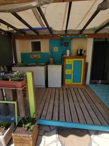 een keuken met een houten vloer en een keuken met een fornuis bij Le P'tit gîte in Saint-Privat