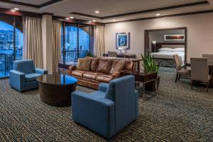 a hotel room with a couch and chairs and a bed at Sheraton Salt Lake City in Salt Lake City