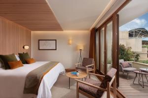 a hotel room with a bed and a balcony at Hotel Marqués de Riscal, a Luxury Collection Hotel, Elciego in Elciego