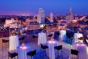 a view of a rooftop bar with tables and chairs at Sheraton Brooklyn New York in Brooklyn