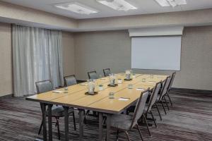 a conference room with a large wooden table and chairs at Courtyard by Marriott Greensboro in Greensboro