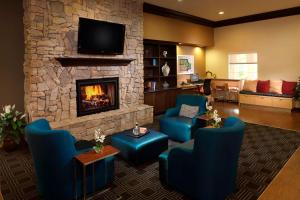 a living room with blue chairs and a fireplace at TownePlace Suites Houston Intercontinental Airport in Houston