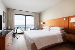 a hotel room with a large bed and a balcony at Riviera Marriott Hotel La Porte De Monaco in Cap d'Ail