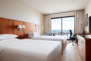 a hotel room with two beds and a view of the ocean at Riviera Marriott Hotel La Porte De Monaco in Cap d'Ail