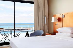 a hotel room with a bed and a view of the ocean at Riviera Marriott Hotel La Porte De Monaco in Cap d'Ail