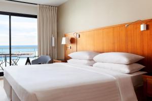a bedroom with a large white bed and a balcony at Riviera Marriott Hotel La Porte De Monaco in Cap d'Ail