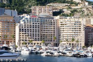 un gruppo di imbarcazioni ormeggiate in un porto con edifici di Riviera Marriott Hotel La Porte De Monaco a Cap d'Ail
