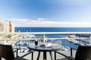 a balcony with a table and chairs and a marina at Riviera Marriott Hotel La Porte De Monaco in Cap d'Ail