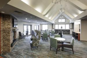 una sala de espera con mesas y sillas y una chimenea en Residence Inn by Marriott Dothan en Dothan