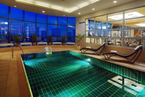 a swimming pool in a hotel with a view of the city at Sheraton Poznan Hotel in Poznań