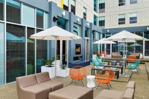 an outdoor patio with chairs and tables and umbrellas at Aloft Austin Northwest in Austin