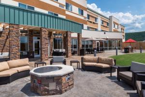 een patio met een vuurplaats voor een gebouw bij Courtyard by Marriott Elmira Horseheads in Horseheads