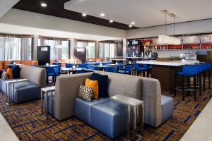 a restaurant with blue couches and a bar at Courtyard Kansas City Overland Park/Metcalf, South of College Boulevard in Overland Park