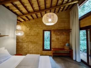 a bedroom with two chandeliers and a bed in a room at Chalés Vila Floresta in Alto Paraíso de Goiás