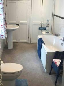 a bathroom with a tub and a toilet and a sink at Lilly’s Cottage, Filey, Sleeps 8 in Filey