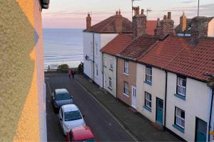 a view of a street with cars parked on the street at Lilly’s Cottage, Filey, Sleeps 8 in Filey