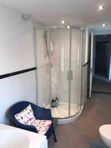 a bathroom with a shower and a chair in a room at Lilly’s Cottage, Filey, Sleeps 8 in Filey