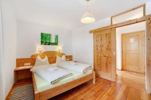 a bedroom with a bed with a wooden headboard at Ferienwohnungen Zwick Spinei in Burgusio