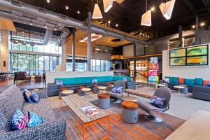 a lobby with couches and tables in a building at Aloft Birmingham Soho Square in Homewood