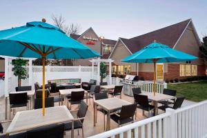 a patio with tables and chairs and blue umbrellas at Residence Inn by Marriott Waco in Waco