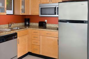 a kitchen with a white refrigerator and a sink at Residence Inn by Marriott Waco in Waco