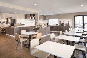 a restaurant with tables and chairs and a kitchen at Residence Inn by Marriott Long Beach in Long Beach