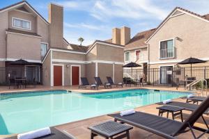 長灘的住宿－Residence Inn by Marriott Long Beach，一座带躺椅的游泳池和一座建筑