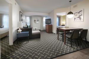 a hotel room with a bed and a dining room at Residence Inn Dallas Addison/Quorum Drive in Dallas