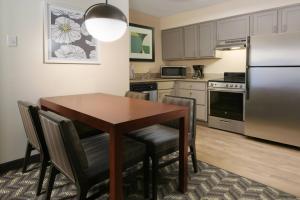 uma cozinha com uma mesa e cadeiras e um frigorífico em Residence Inn Dallas Addison/Quorum Drive em Dallas