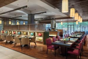 un ristorante con tavoli e sedie e un bar di JW Marriott Hotel Beijing a Pechino