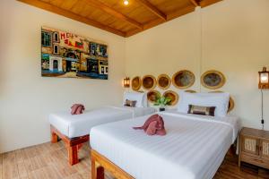 sypialnia z dwoma łóżkami i obrazem na ścianie w obiekcie Khao Sok River Home Resort w Khao Sok