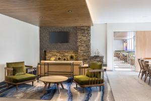 a lobby with chairs and a table and a fireplace at Fairfield Inn & Suites by Marriott Des Moines Downtown in Des Moines