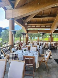 a restaurant with white tables and chairs on a patio at Pirin Golf Villa Compass Property in Bansko