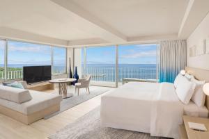 um quarto com uma cama branca e vista para o oceano em IRAPH SUI, a Luxury Collection Hotel, Miyako Okinawa em Ilhas Miyako