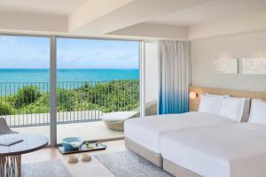 IRAPH SUI, a Luxury Collection Hotel, Miyako Okinawa في جزيرة مياكو: غرفة نوم مع سرير وإطلالة على المحيط