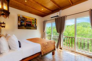a bedroom with a bed and a large window at Khao Sok River Home Resort in Khao Sok National Park