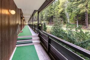 ショナッハにあるTerrassenpark Schonach App 161の緑の床と木の壁の廊下