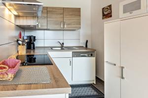 a kitchen with white cabinets and a sink at Terrassenpark Schonach App 161 in Schonach