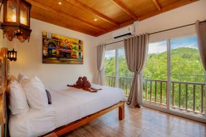 a bedroom with a bed and a balcony at Khao Sok River Home Resort in Khao Sok National Park