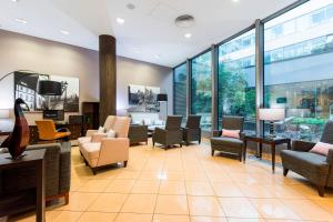 a lobby with chairs and tables and windows at Courtyard by Marriott Prague City in Prague