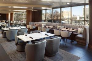 un restaurante con mesas, sillas y ventanas en Chattanooga Marriott Downtown, en Chattanooga