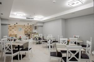 un comedor con mesas y sillas blancas en Hotel Boutique Refael en Truskavets