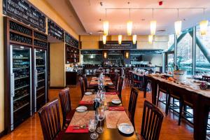 a restaurant with wooden tables and chairs and a bar at Courtyard by Marriott Prague City in Prague