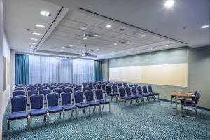 a conference room with blue chairs and a screen at Courtyard by Marriott Prague City in Prague