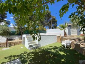 un patio con una escalera y un banco en el césped en Casita rural con piscina, en La Torre de Claramunt