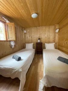 um quarto com 2 camas num chalé de madeira em Casita rural con piscina em La Torre de Claramunt