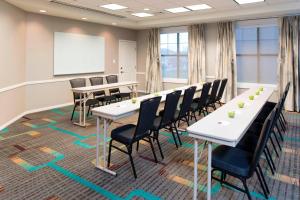 uma sala de conferências com mesas e cadeiras e um quadro branco em Residence Inn Moline Quad Cities em Moline