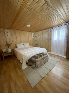 1 dormitorio con 1 cama grande y techo de madera en Casita rural con piscina, en La Torre de Claramunt