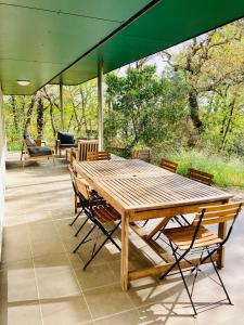 un tavolo e sedie di legno su un patio di Le Domaine de la Montagnette a La Teste-de-Buch