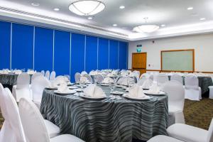 a conference room with tables and white chairs at Courtyard by Marriott Villahermosa Tabasco in Villahermosa